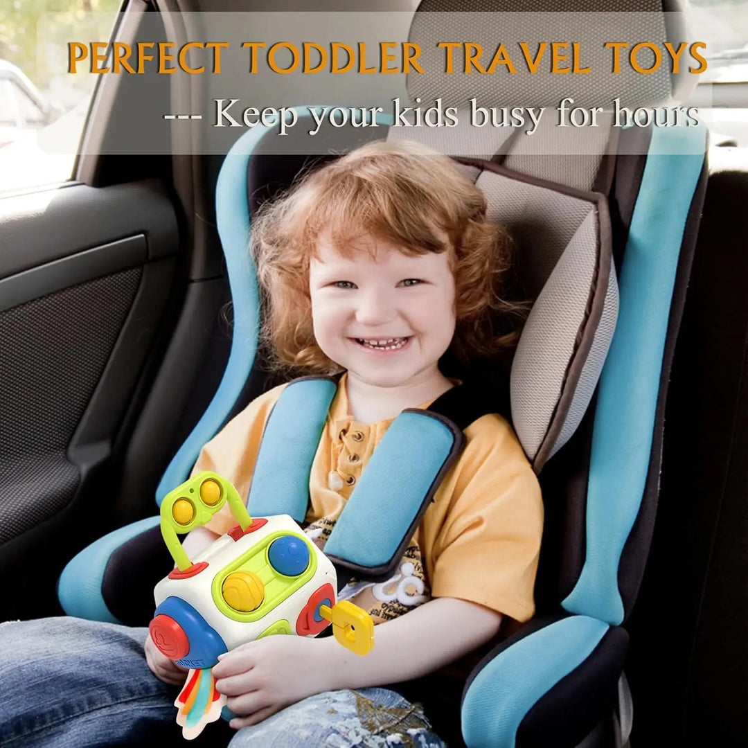 Child holding a colorful activity cube while seated in a car seat