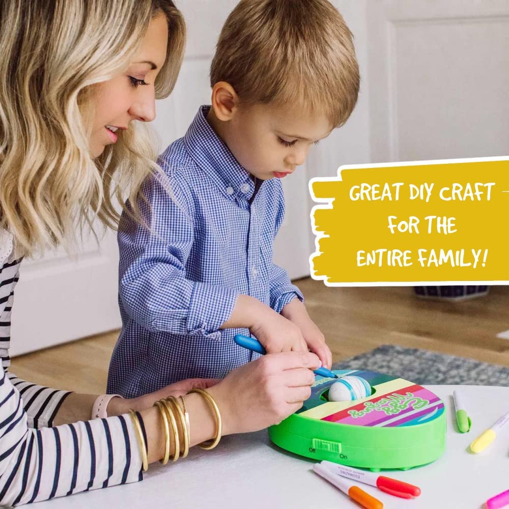 An adult and child decorate an egg together using the green rotating egg decorator