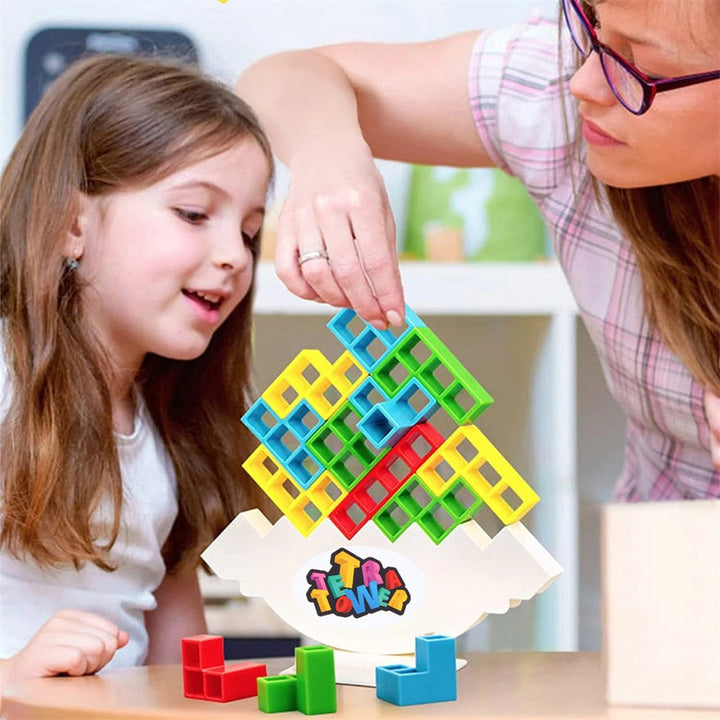 An adult and child build a colorful block tower together on a tabletop.