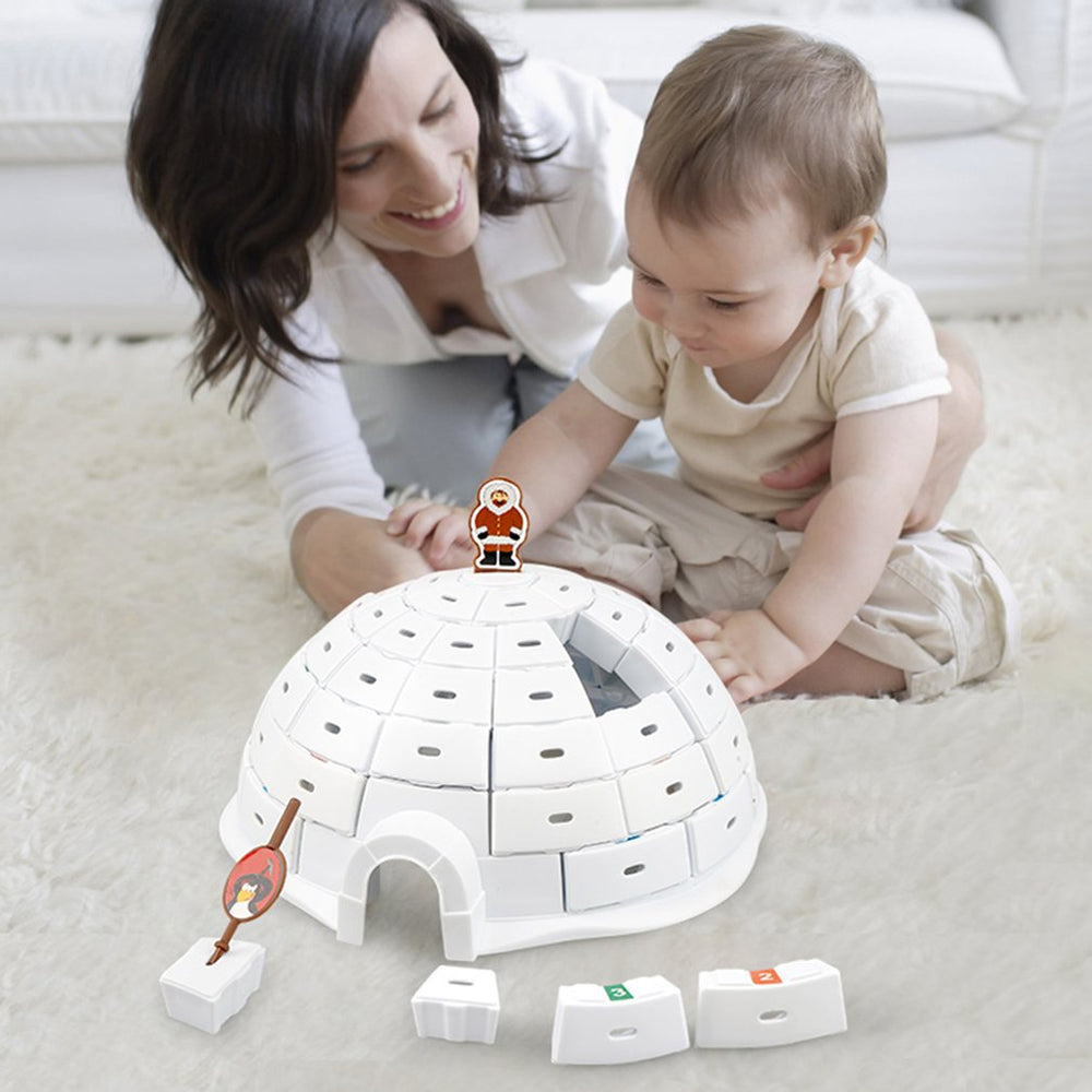 Adult and child beside the assembled white igloo game and loose blocks