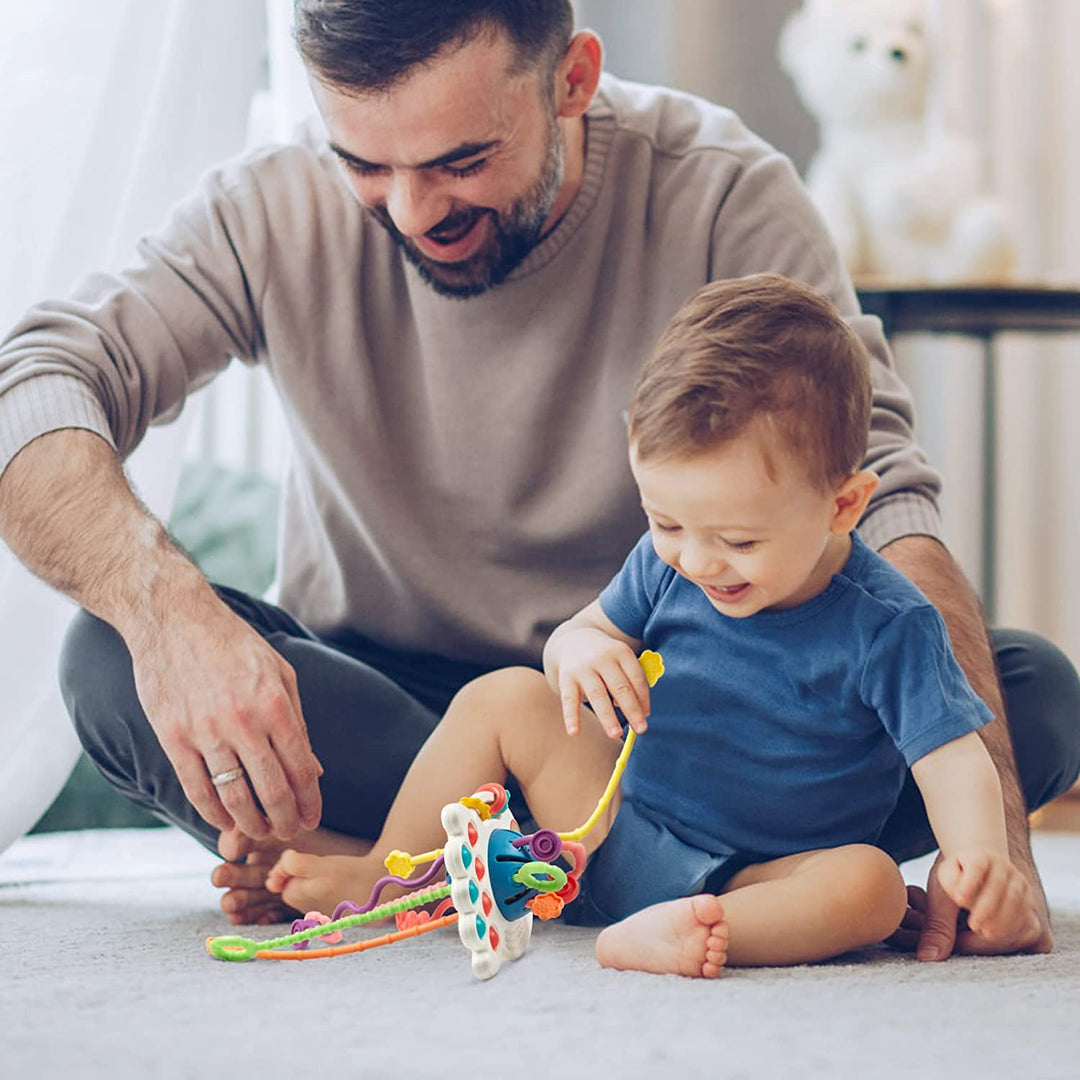 Adult and toddler exploring the colorful pull cords of a UFO-style sensory toy