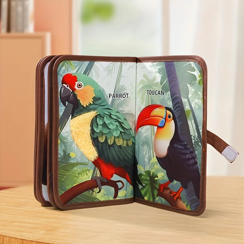 Fabric animal book opened to a parrot and toucan spread with a textured parrot patch.