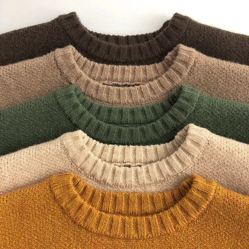 Close-up of ribbed crew necks on brown, khaki, green, beige, and yellow knit sweaters