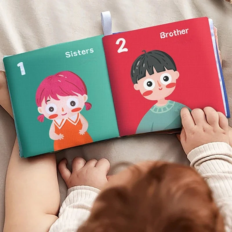 Baby exploring an open family-themed cloth book with illustrated sister and brother pages