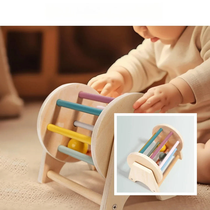 Baby touching the colorful bars of a wooden rolling drum, with an inset view of the toy