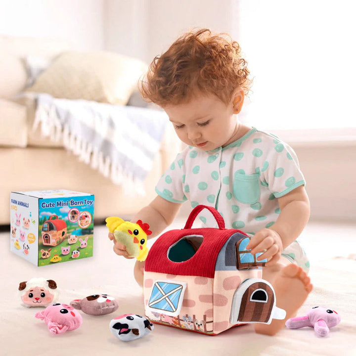 Baby playing with a soft red-roof farmhouse and plush farm animals