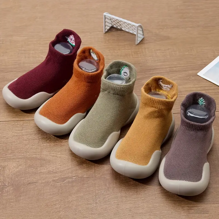 Front view of sock-style baby shoes in red, orange, green, yellow, and brown