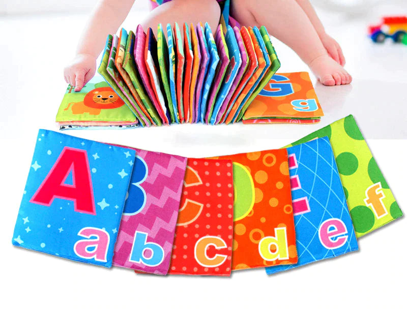 Colorful alphabet cloth books spread out in front of a seated baby