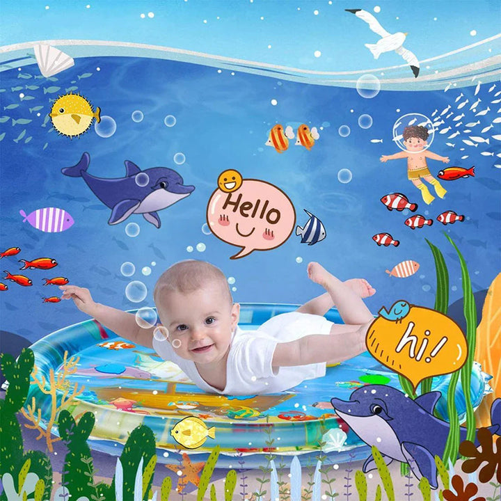 Baby practicing tummy time on a round water mat surrounded by colorful ocean illustrations