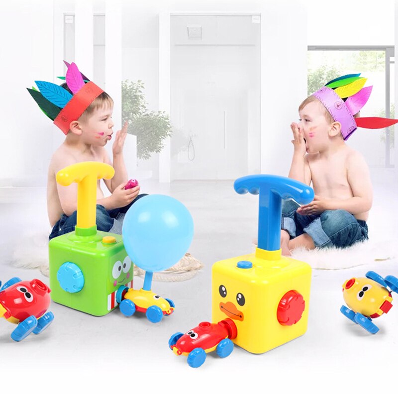 Two children playing with green and yellow pumps and colorful balloon-powered cars