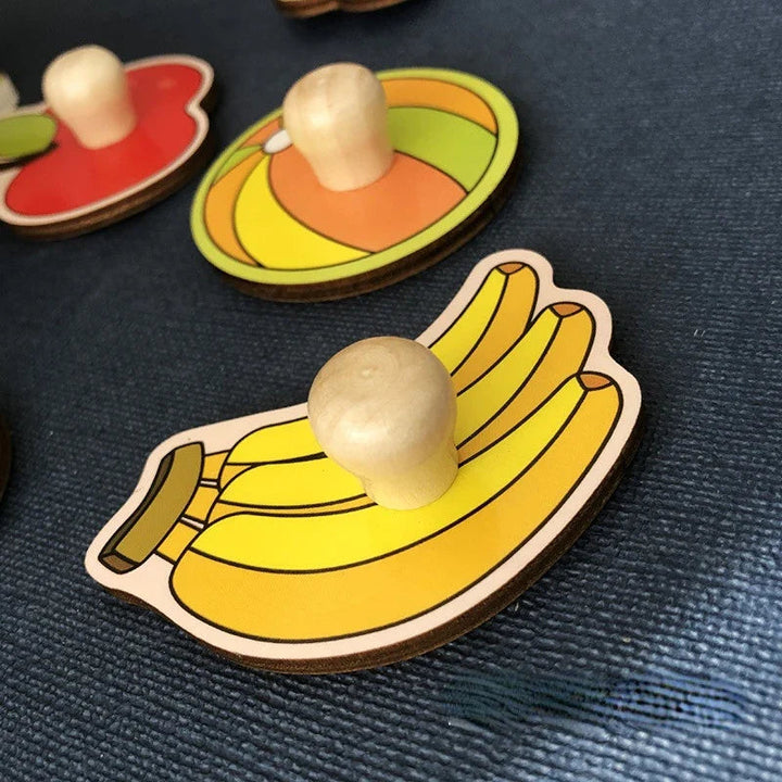 Close-up of wooden banana and ball puzzle pieces with rounded peg handles
