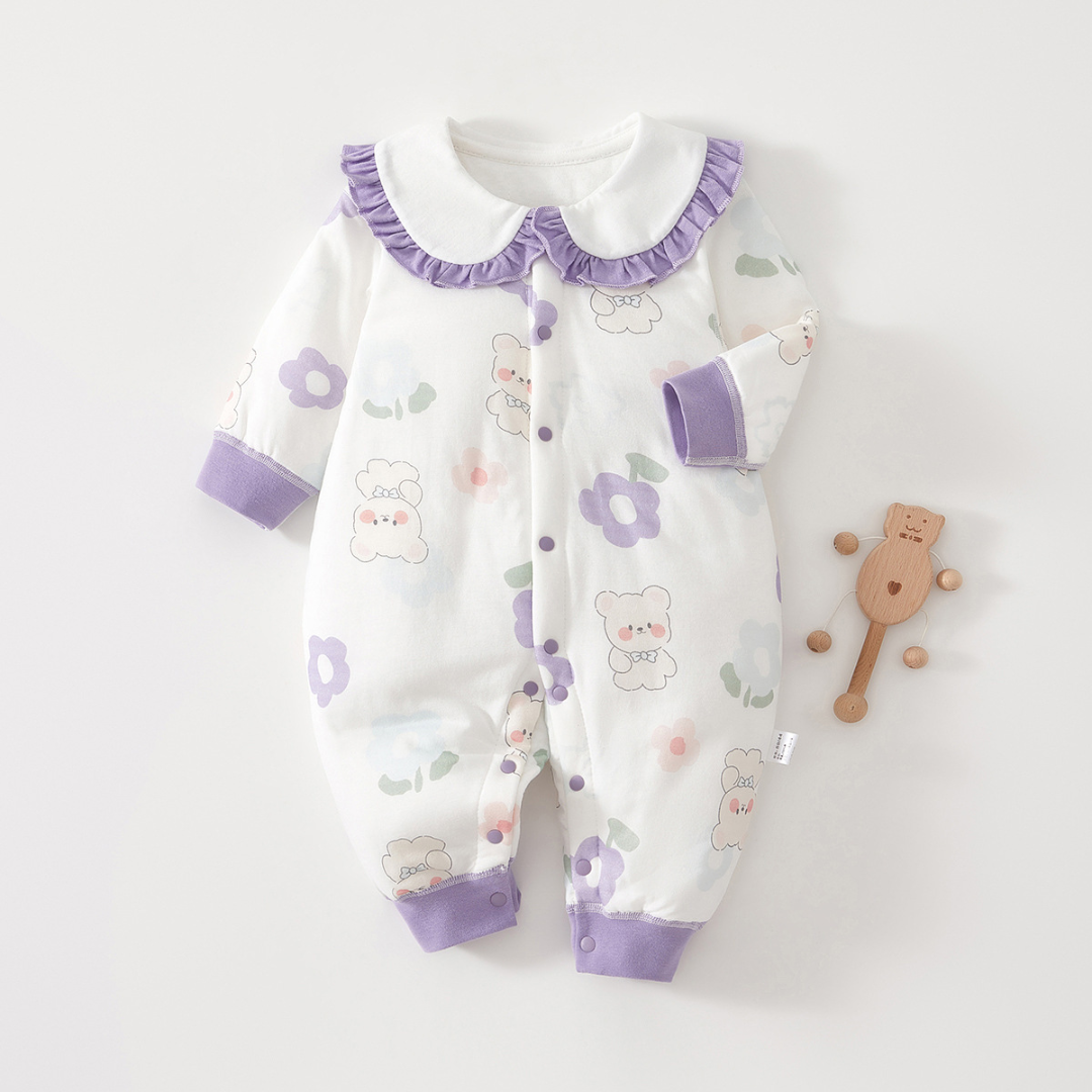 Bear-and-flower baby pajamas with purple cuffs and a ruffled collar