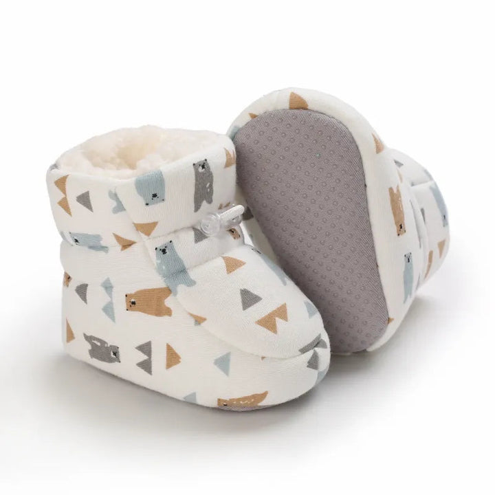 Bear-print baby slippers with one slipper turned to show its gray textured sole