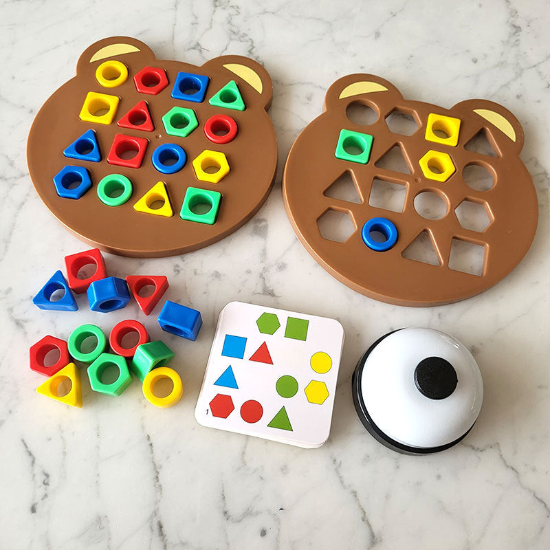 Filled and partially filled bear puzzle boards with loose pieces, a pattern card, and a bell