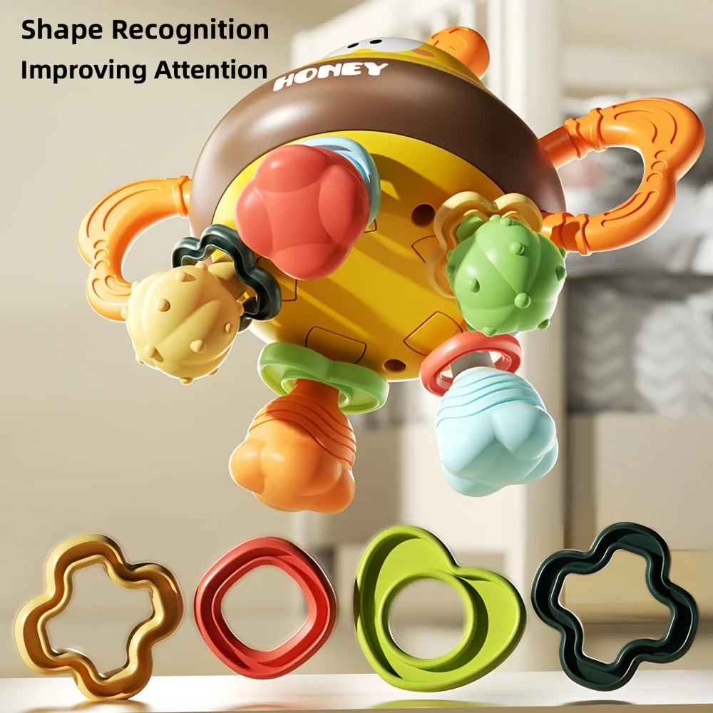 Underside of the bee rattle with textured teething pieces and four shaped rings shown below