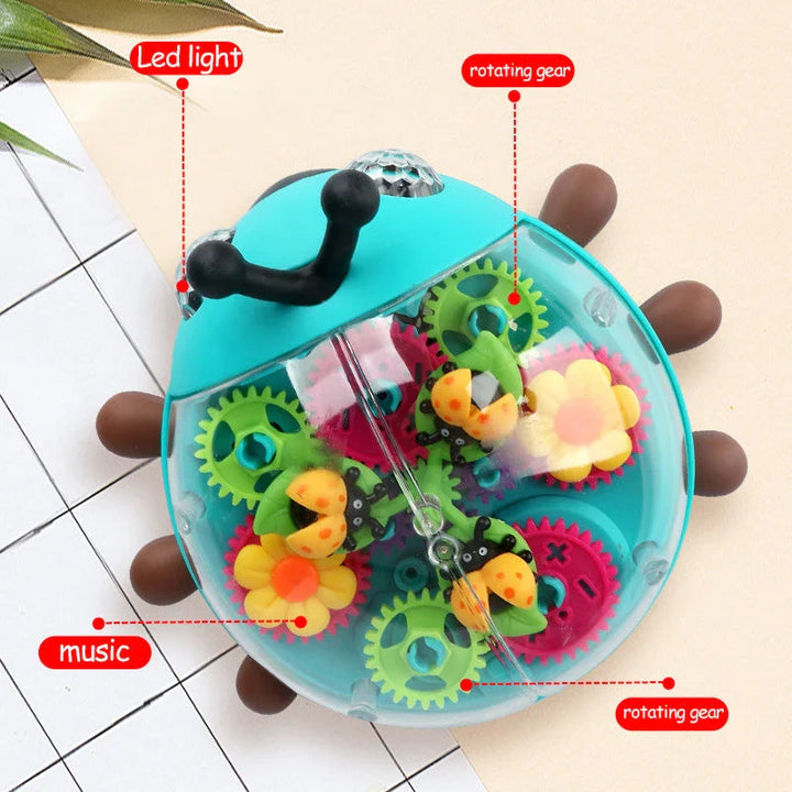 Clear shell of the beetle toy showing colorful gears, flower shapes, and ladybug details