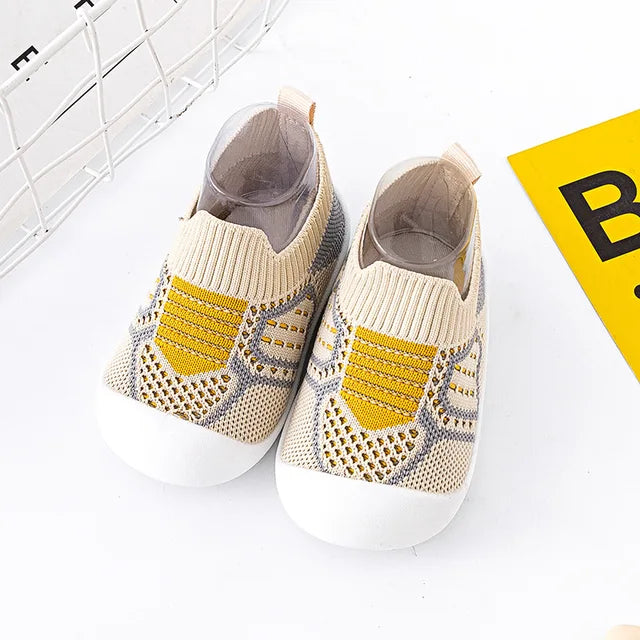 Beige baby slip-on shoes with yellow knit accents and white soles