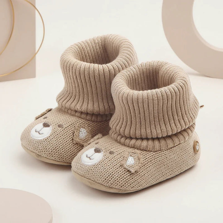 Pair of beige bear-face baby booties with folded cuffs, shown at an angle.