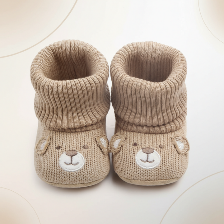 Front view of beige bear-face baby booties with wide folded ribbed cuffs.