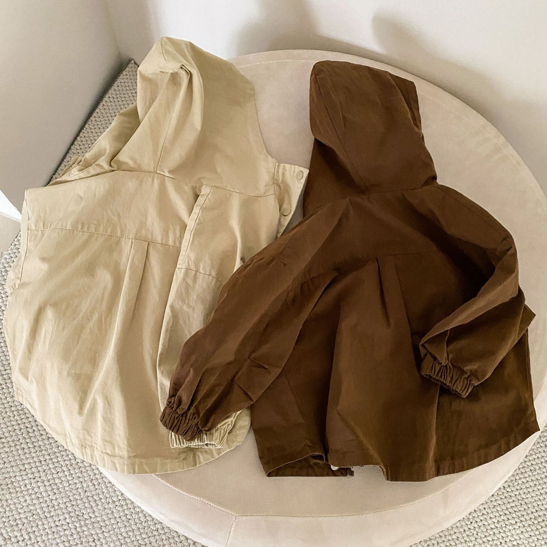 Beige and brown parkas laid flat with hoods and elastic cuffs