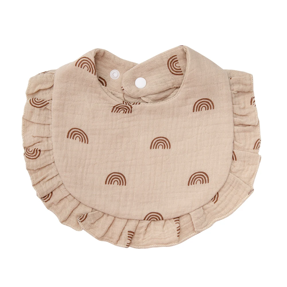 Beige cotton baby bib with brown rainbow motifs and a matching ruffled edge