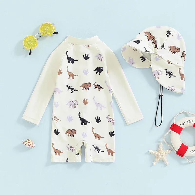 Beige dinosaur-print one-piece swimsuit with long sleeves, short legs, and a matching neck-flap hat.