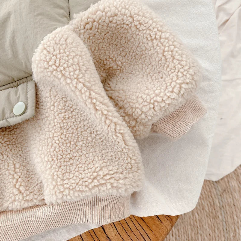 Beige teddy-textured fleece sleeve and ribbed cuff beside the jacket&