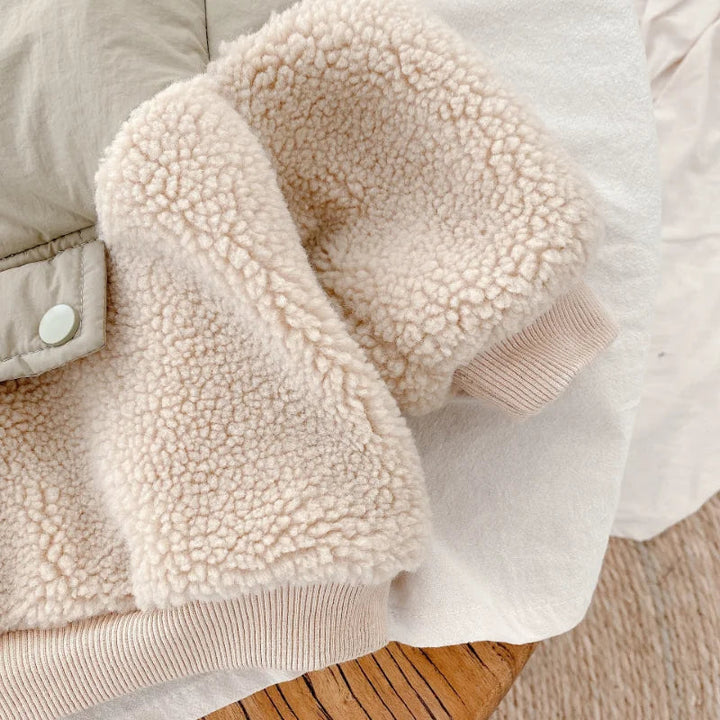 Beige teddy-textured fleece sleeve and ribbed cuff beside the jacket&