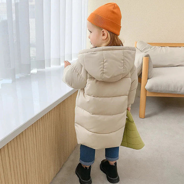 Back view of a child wearing a beige hooded winter coat