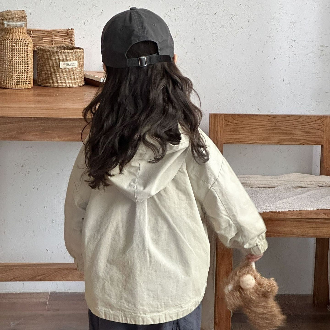 Back view of a child wearing a beige parka with the hood down