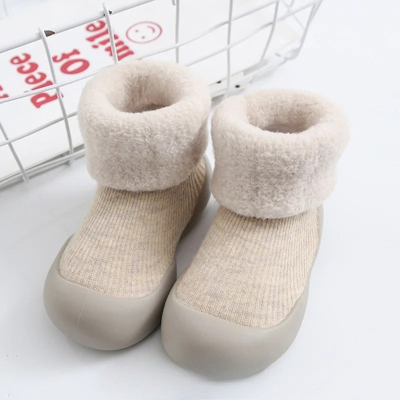 Beige ribbed baby socks with plush folded cuffs and light-colored soles