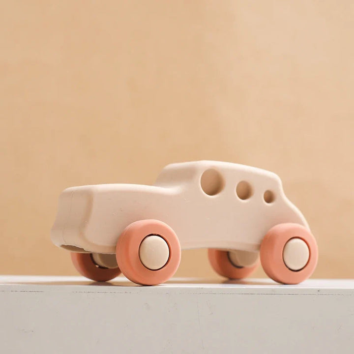 Beige silicone toy car with coral wheels and three round window openings