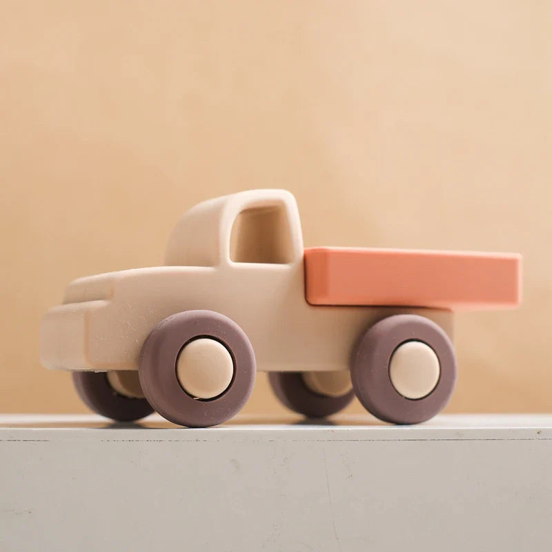 Beige silicone toy truck with a coral bed and dark wheels
