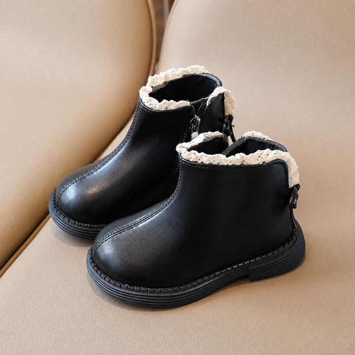 Pair of black ankle boots with rounded toes, black soles, and cream trim
