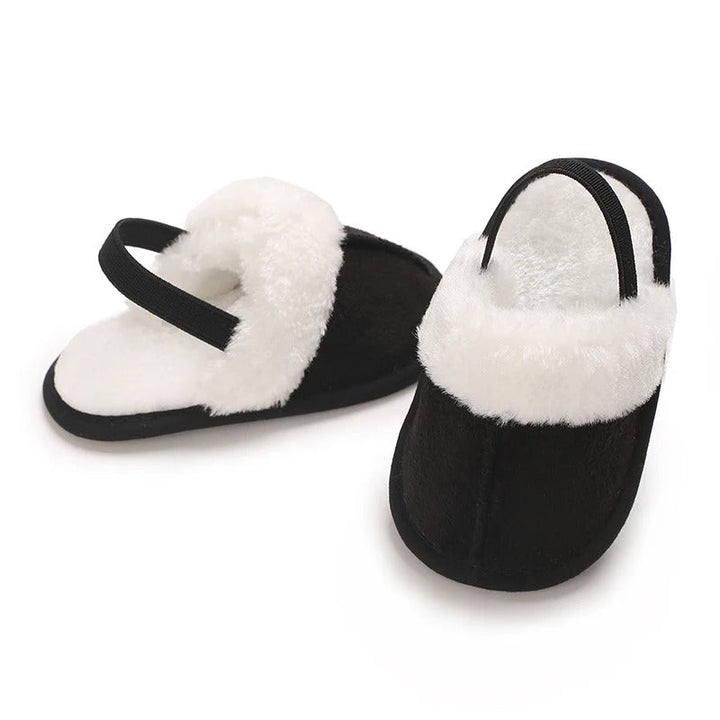 Black baby slippers showing white plush trim, lining and heel straps