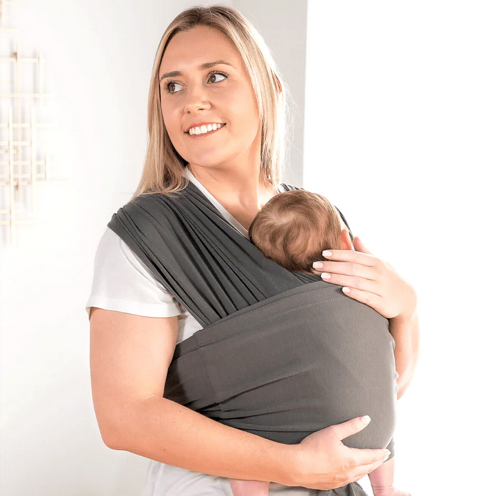Parent carrying a baby against her chest in a black baby wrap