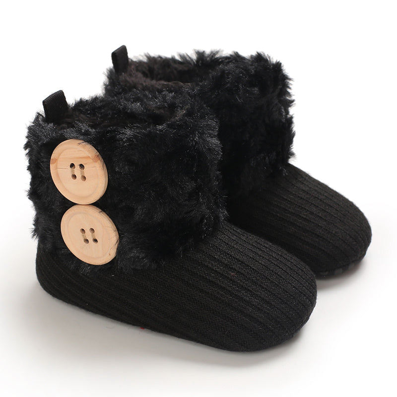 Black baby boots with fluffy cuffs and two contrasting decorative buttons