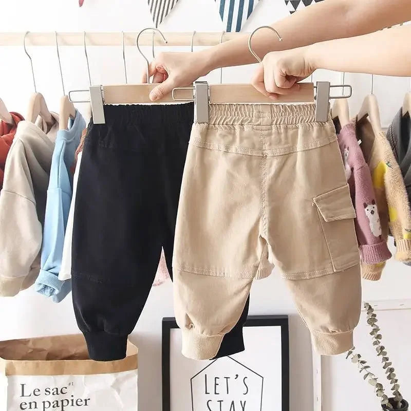Back view of black and khaki cargo pants with gathered waistbands and ribbed cuffs