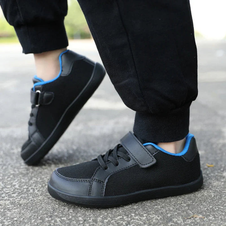 Black mesh sneakers with blue collar trim worn outdoors