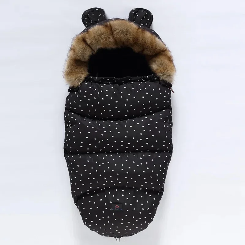Black stroller footmuff with scattered white dots and a faux fur collar