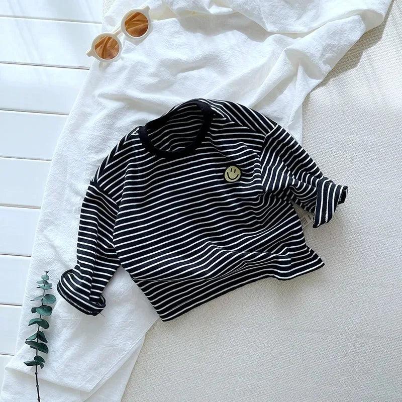 Black long-sleeve shirt with thin white stripes, a crew neck, and a small smile patch.
