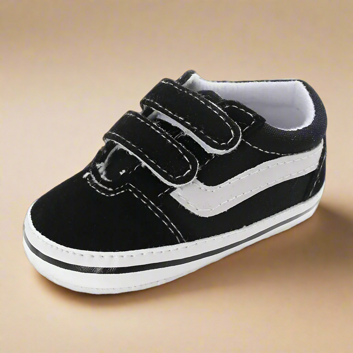Black-and-white baby sneaker with a white side stripe and two straps
