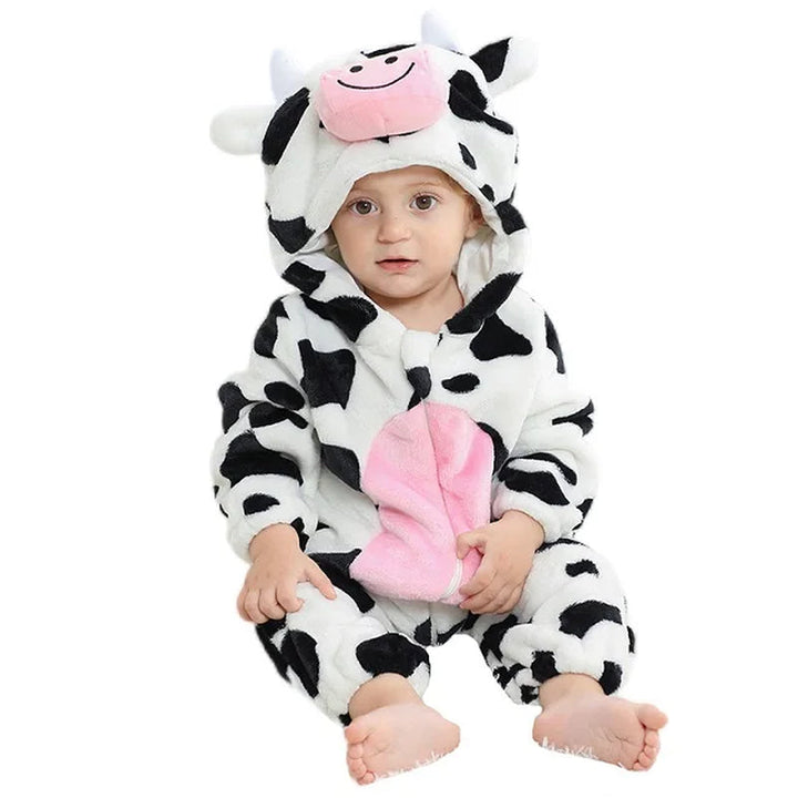Baby wearing a black and white cow romper with a pink belly and cow-face hood.