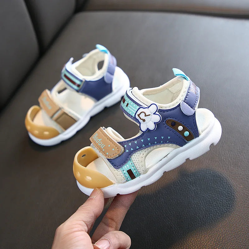 Blue A kids' sandals with flower accents, tan toe caps, and white soles