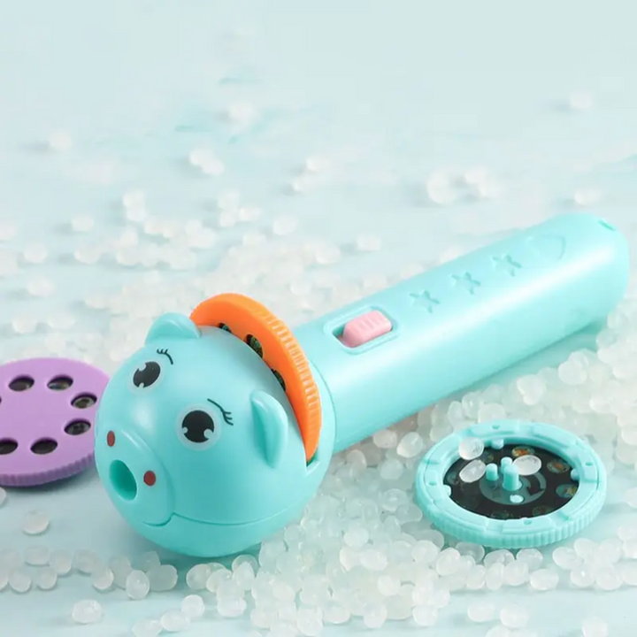 Blue animal-face projector flashlight beside purple and blue picture discs.