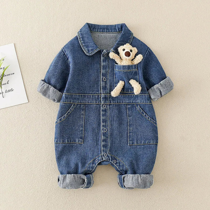 Front of the blue baby jumpsuit with a collar, front pockets, and a bear detail at the chest.