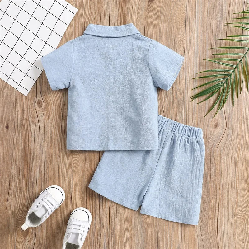 Back view of the blue short-sleeve shirt with matching shorts on a wood background