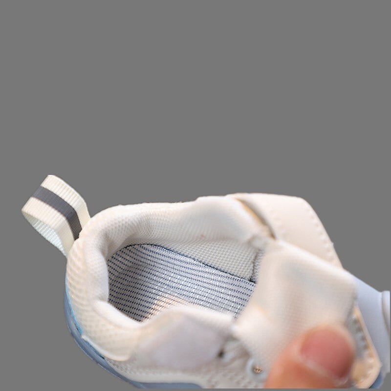 Padded collar and striped insole inside a blue and white baby shoe