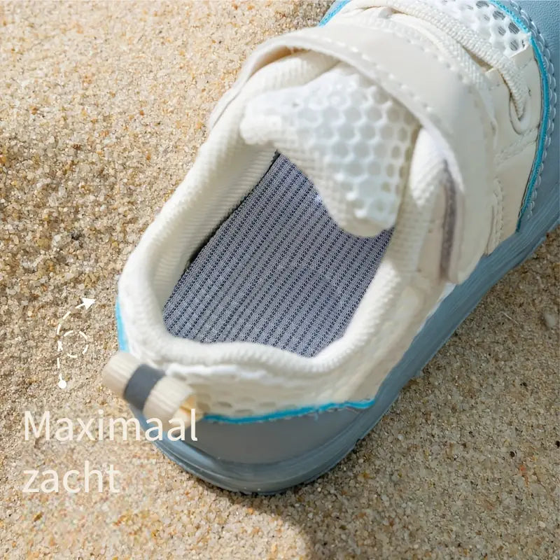 Top view of a blue mesh baby shoe showing its padded opening and striped insole