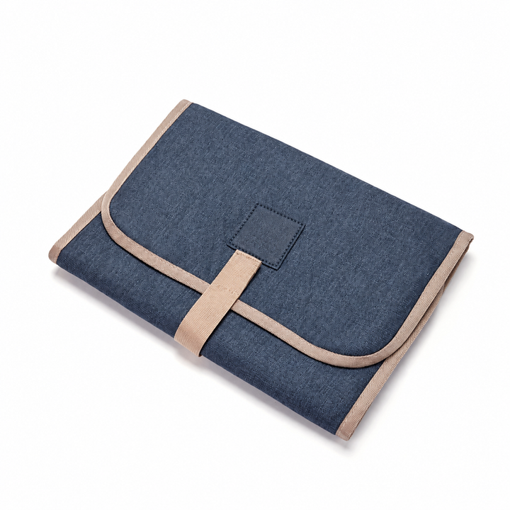 Blue baby changing mat folded with beige edging and a front strap